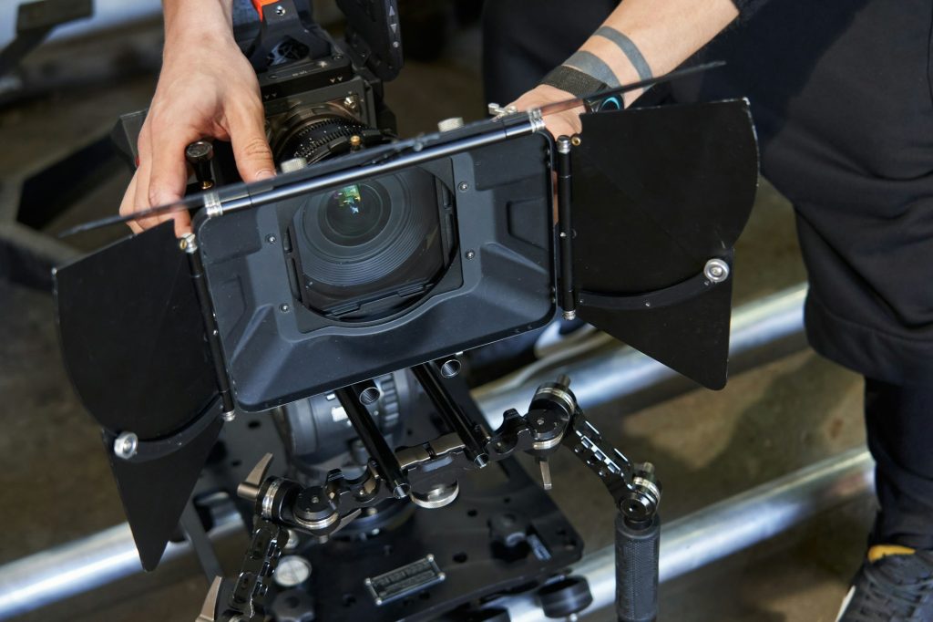 male hands of a videographer prepare a professional video camera for video filming. the camera